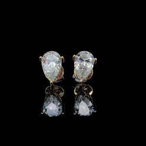 Elegant pear-shaped diamond earrings on reflective black surface.