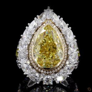 Pear-shaped yellow diamond ring with a double halo of white diamonds on a black background.